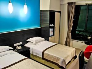 Kampong Nipah PanjangにあるIn Trend Hotelのベッドが2つあり、青い壁の寝室