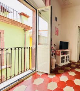 an open door to a balcony with a television at Appartamento vacanze Le rose in Bosa