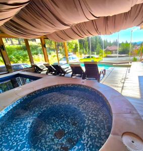 a hot tub in a house with chairs around it at Апартамент Орфинда- Pamporovo in Pamporovo