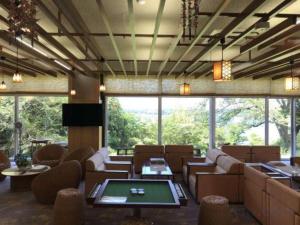 a large room with couches and tables and windows at Hotel New Katsura in Sado