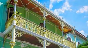 a balcony of a green building with gold railing at Hotel Seri Pauh in Jalan Baharu