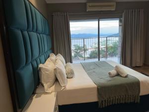 a bedroom with a large bed with a large window at BY Guest House in Hartbeespoort