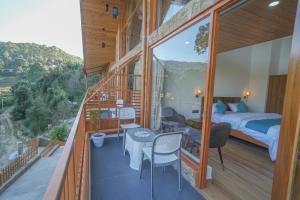 a room with a bedroom and a bed on a balcony at The Trishul Vista in Mukteshwar +13 photos