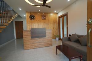 a living room with a couch and a clock on a wall at The Trishul Vista in Mukteshwar