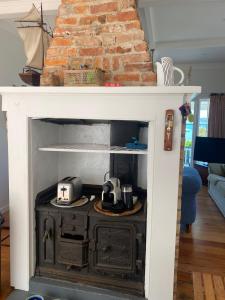 a white fireplace with a stove in a living room at Russell Waterfront Historic Cottage in Russell +37 photos
