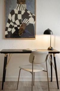 a desk with a chair and a picture on the wall at Valby family apartment in Copenhagen