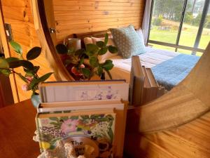 a bedroom with a bed and a window with plants at The Cabin By the Sea - Cosy Waterfront Getaway in Lunawanna +35 photos