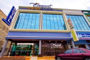 a store with a car parked in front of it at Elegant Hotel in Kampong Linau