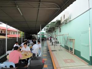 a group of people sitting at tables in a building at Hotel Hung Hung in Kampung Boyan