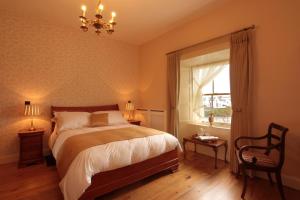 a bedroom with a bed and a window and a chandelier at Corrib House Guest Accommodation in Galway