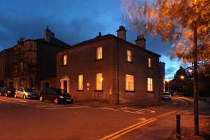 een groot bakstenen gebouw met verlichte ramen in een straat bij Corrib House Guest Accommodation in Galway