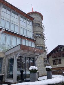 un edificio con una torre de reloj en la nieve en Lifestyle & Spa Hotel Grächerhof, en Grächen