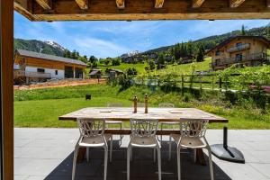 a wooden table and chairs on a patio at Chalet Panaga in La Tzoumaz