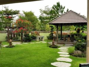 a garden with a gazebo and green grass at Serdang Business Hotel in Serdang