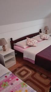 a bedroom with two beds and a table with two lamps at Guest House Adrijana in Seliste Dreznicko +107 photos