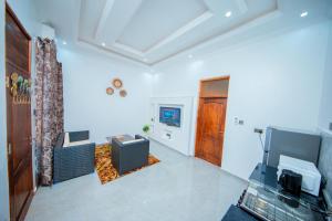 een woonkamer met een bank en een televisie bij Negamsi Park in Babati +3 foto's