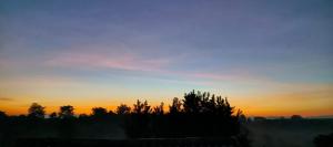 Ban Pa ThonRai Phuchat的一片落日,在前方的树林中