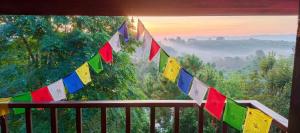 a view from a balcony with colorful prayer flags at Rai Phuchat in Ban Pa Thon