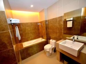 a bathroom with a toilet and a sink and a tub at Eminent Hotel in Kampong Kabusik +108 photos
