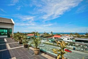 a balcony with palm trees and a view of a street at Friendly Hotel in Kudat