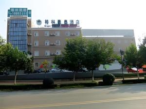 a city street with a building in the background at GreenTree Inn Laiwu Frank in Zhaizi
