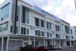 un edificio bianco con auto parcheggiate di fronte di Place2stay @ Campus Hub a Kampong Merdang Limau