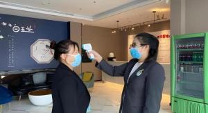 two women wearing face masks in a store at Magnotel Business Harbin Railway Station Qiulin Museum Metro Station in Harbin