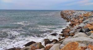 a rocky shoreline with waves crashing on the ocean at OYO 90577 Safi Homestay in Kampong Tanjong Gelam