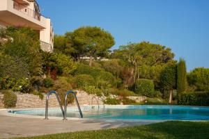 a swimming pool with a slide in front of a building at Appartment - Panoramic Sea View - Swimming Pool in Villefranche-sur-Mer
