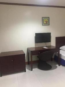 a bedroom with a desk with a computer and a bed at Jeamco Royal Hotel - Baybay in Baybay