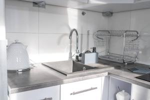 a kitchen counter with a sink and a mixer at Apartly - Apartament Wyszyńskiego z loggią in Szczecin