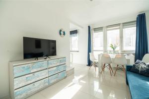 a living room with a television on a dresser at Apartly - Apartament Wyszyńskiego z loggią in Szczecin +11 photos