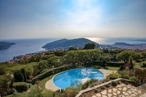 an aerial view of a swimming pool on a hill next to the ocean at Appartment - Panoramic Sea View - Swimming Pool in Villefranche-sur-Mer