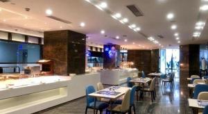 a restaurant with tables and chairs and a bar at Qingyuan Zhongkai Huafu Holiday Hotel in Xiaoshi