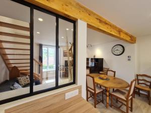 a dining room with a table and a clock on the wall at Gite Mirabelle in Moyenmoutier