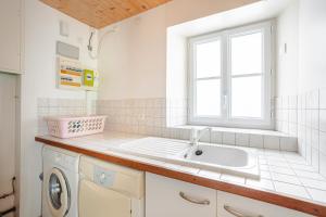 a white kitchen with a sink and a window at Appartement Ars-en-Ré Heraudeau in Ars-en-Ré