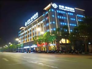 a lit up building with motorcycles parked in front of it at Chonpines Hotels·Zhongshan Xiaolan LRT Station in Nantou