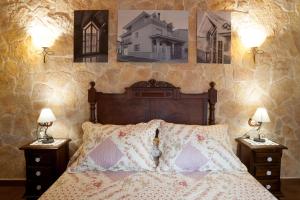 a bedroom with a bed with two nightstands and two lamps at Casa Rural Millán in La Mata de los Olmos +25 photos