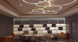 ハルビン市にあるMagnotel Harbin Medical University First Affiliated Hospitalのテーブルと椅子とシャンデリアのあるダイニングルーム