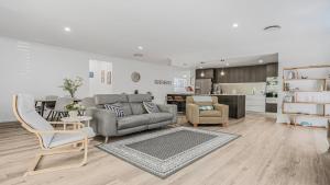 een woonkamer met een bank en stoelen en een keuken bij Salt & Sand Sanctuary in Woorim