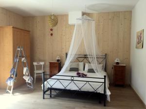1 dormitorio con 1 cama con dosel en B&B Casa Taralin, en Teglio