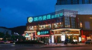 張家界市にあるCity Comfort Inn Hotel Zhangjiajie Railway Station Tianmen Mountain Cableway Stationの側面にネオンサインがある建物