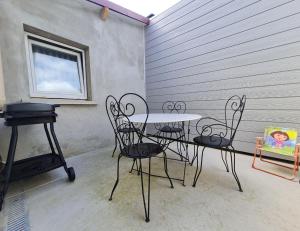a patio with a table and chairs and a grill at Gite Mirabelle in Moyenmoutier +10 photos