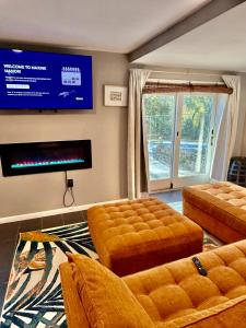 a living room with two ottomans and a tv at Maxine Manor in Douglasville
