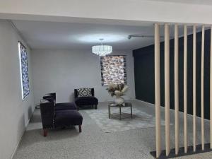 a living room with two chairs and a table at 112 on Park Drive in Port Elizabeth +1 photo