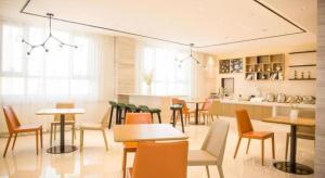 a restaurant with tables and chairs in a room at City Comfort lnn Dayi High-speed Railway Station in Wangsiying