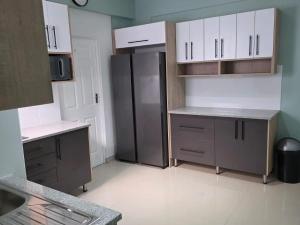 a kitchen with a stainless steel refrigerator and cabinets at 112 on Park Drive in Port Elizabeth