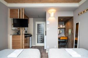 een kleine kamer met 2 bedden en een keuken bij Guest House NANMO in Minami-jūichijō