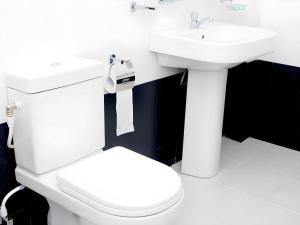 a bathroom with a white toilet and a sink at Sihilro Regency Hotel in Udawalawe