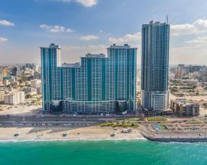 an aerial view of a city with a beach and buildings at Spacious 3BR Seaview Duplex Perfect for Families in Ajman 